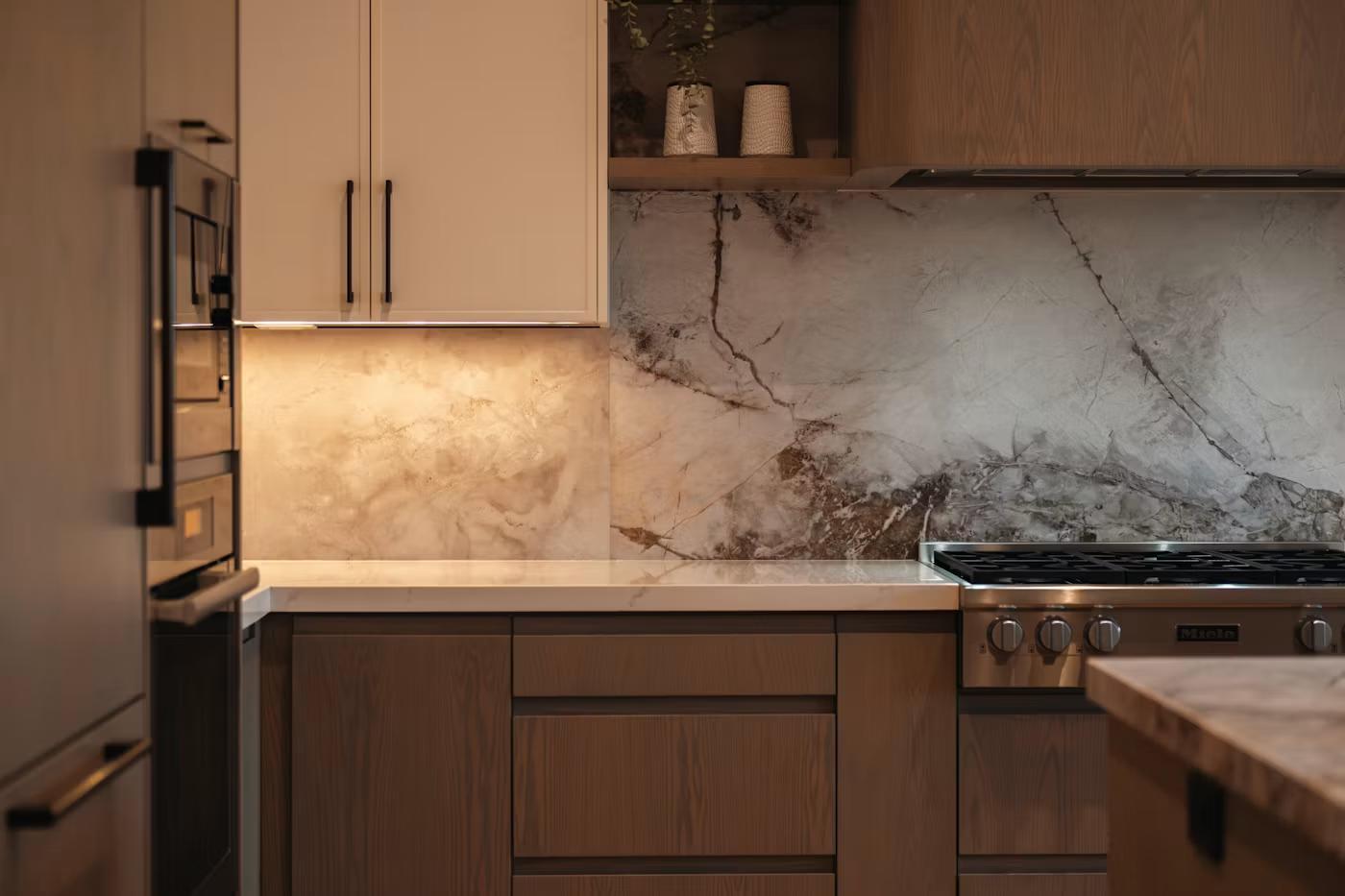 Cooktop with stone backsplash and under-cabinet lighting