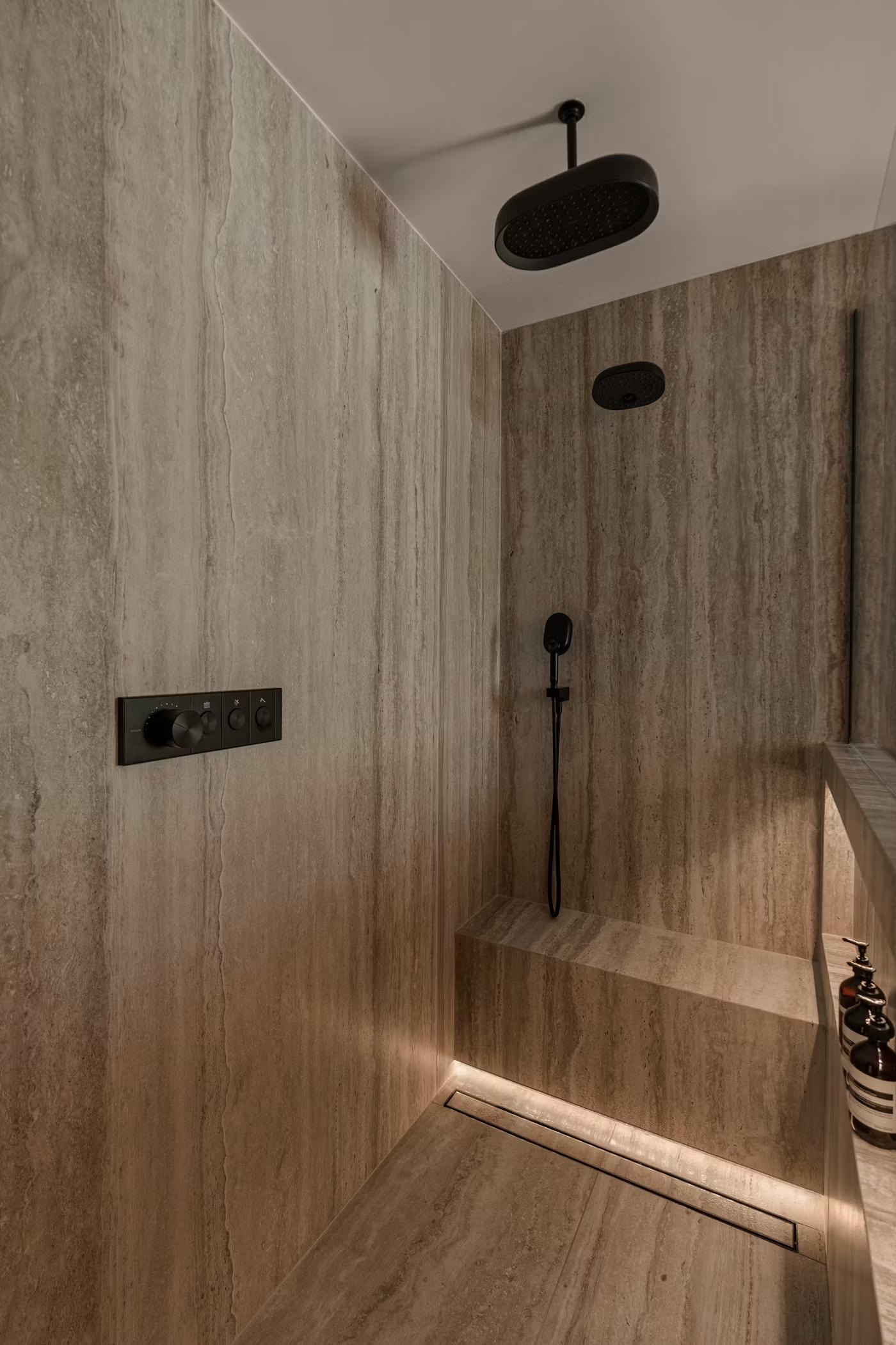 Walk-in shower with rain head, handheld shower, and bench